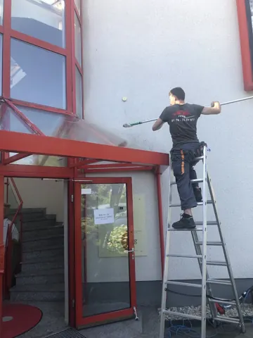 Reinigung am verglasten Eingangsbereich