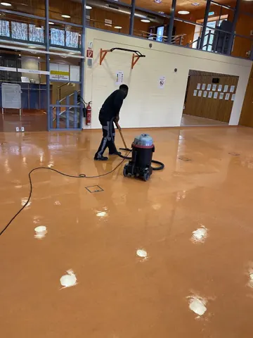 Maschinelle Bodenpflege in einer Halle