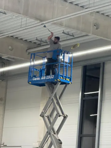Reinigung an der Hallendecke mit Hebebühne
